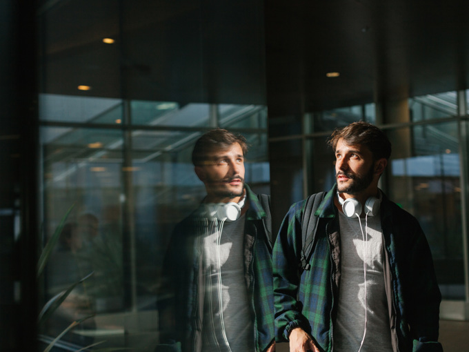 Young Man Reflected In A Glass Wall